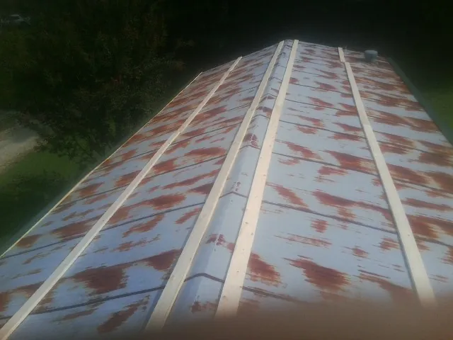 Rusted metal roof panels with new wood purlins before replacement — Storm Damage Roof Repair in New Millport by Roofing Brothers