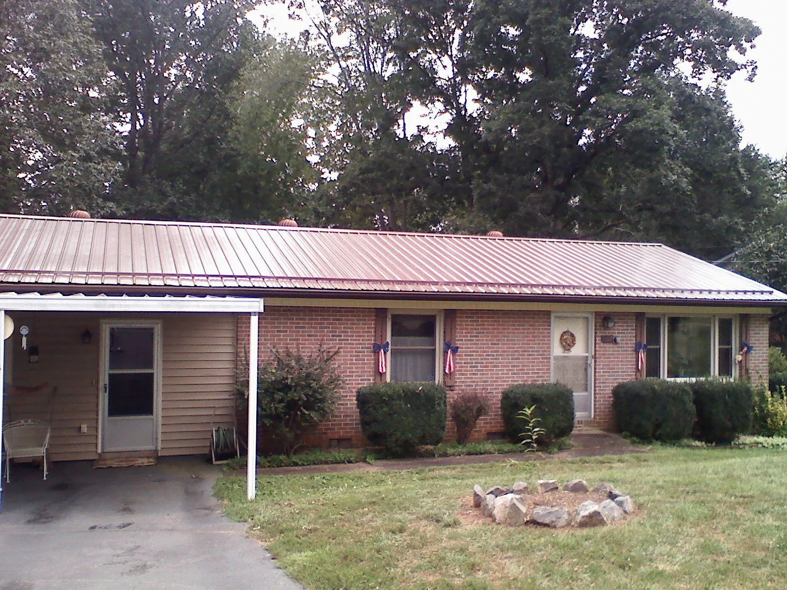 Bronze metal roof and carport on a brick ranch home — Roof Repair work by our crew in New Millport
